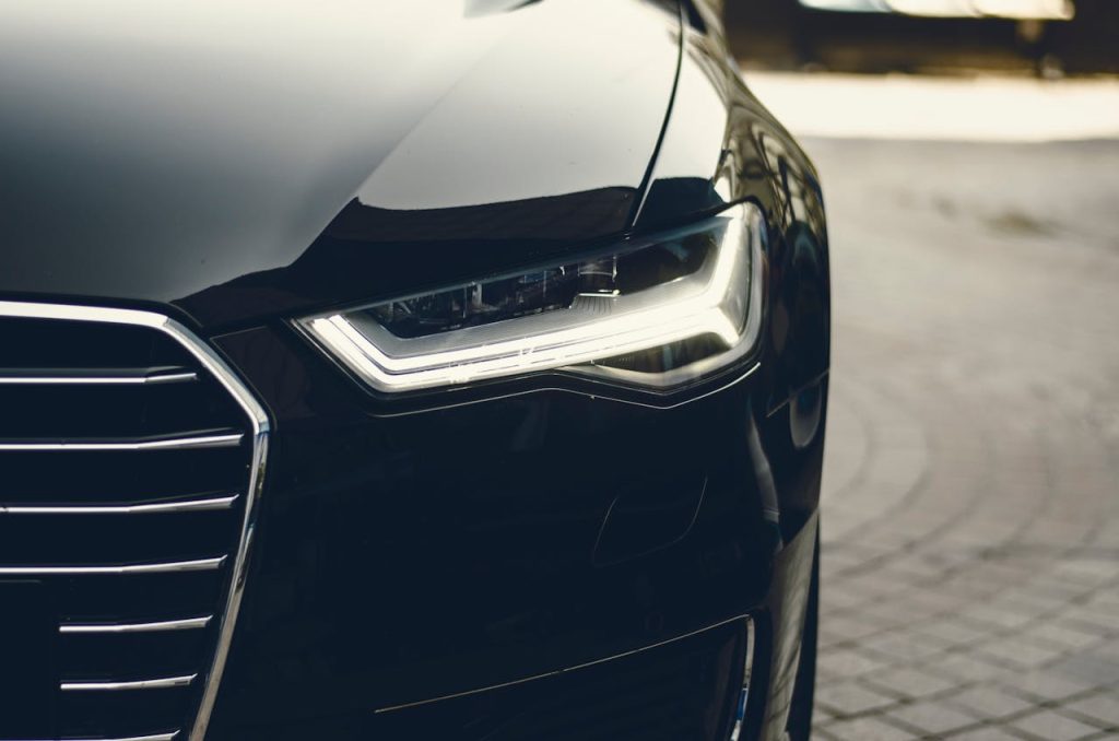 black-car-305070 A sleek, modern luxury car showcasing its chrome detailing and LED headlights on a city street.